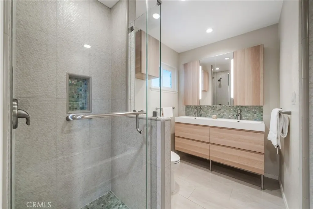 The secondary bath also has a step-in shower and nook for products.