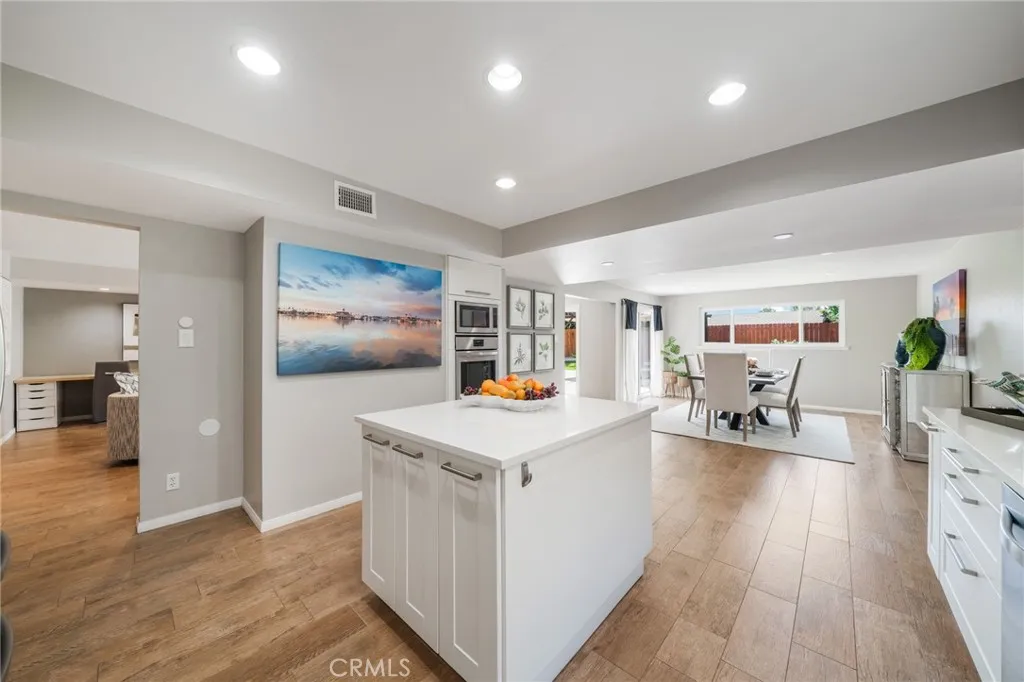 Living room to left and family room to the right. The sunset photo on the wall is the back of fireplace chimney.