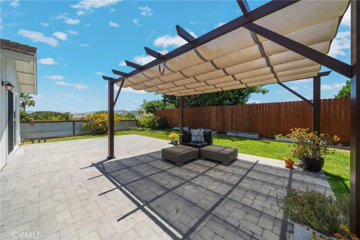 Looking East across the back yard to the hills of San Juan. The pergola and pots conveys with the home