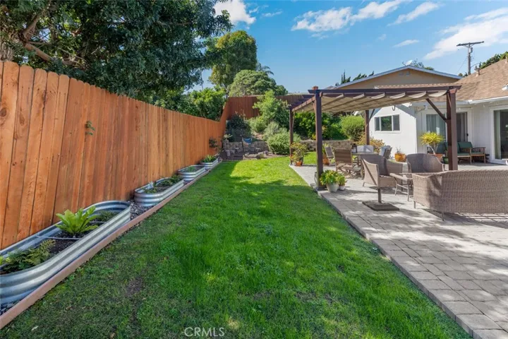 There is a large grass area behind the pergola.