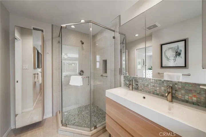 Primary Bath includes a mirrored closet, walk-in shower and dual sinks.