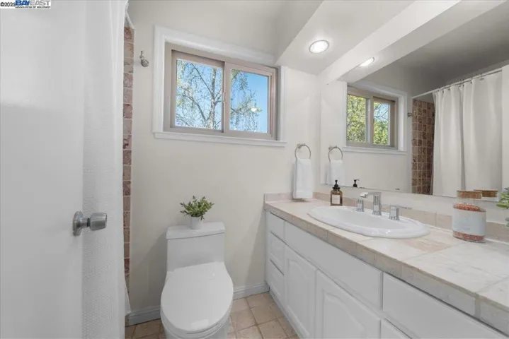 A tasteful toilet room featuring a shower-over-tub combo—for spa-like soaks in comfort and style.