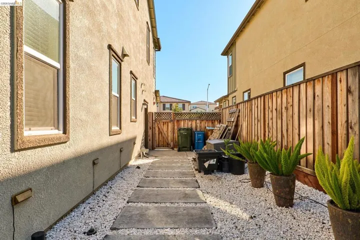 View of home's exterior featuring a fenced backyard, stucco siding, a gate, and crawl space