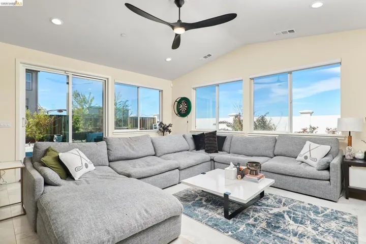 Living room featuring plenty of natural light, recessed lighting, ceiling fan, and vaulted ceiling