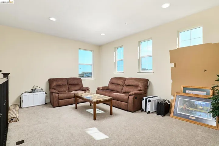 Living area featuring light colored carpet and recessed lighting