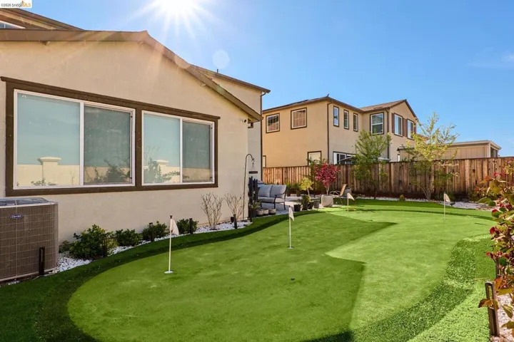 Fenced yard featuring a putting area and an outdoor living space