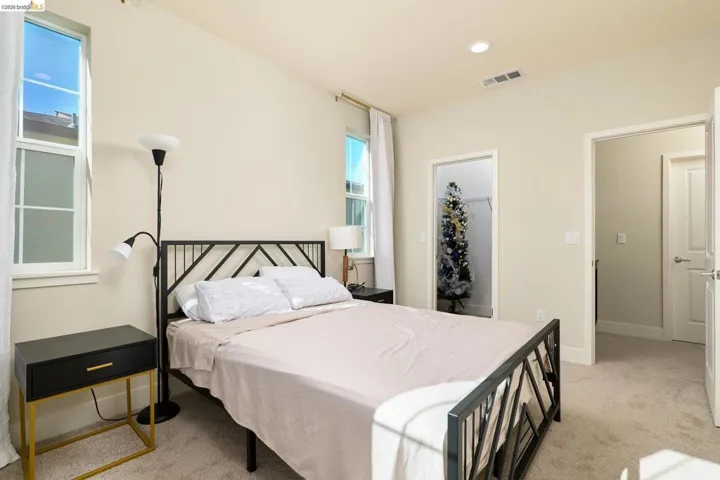 Bedroom featuring light carpet, a spacious closet, and recessed lighting