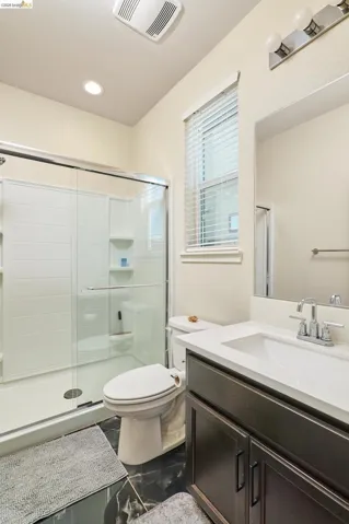Full bathroom with vanity, a stall shower, and recessed lighting