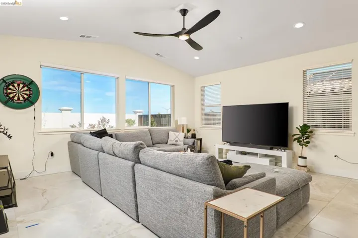 Living area featuring ceiling fan, recessed lighting, and lofted ceiling