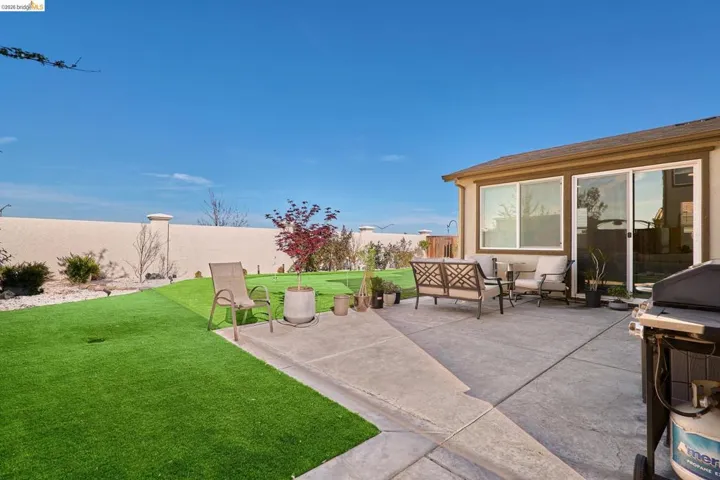 Fenced backyard featuring an outdoor hangout area, a grill, and a patio area