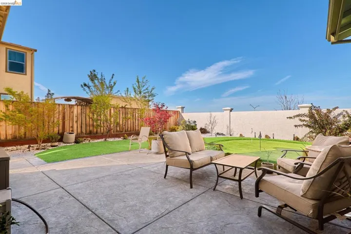 Fenced backyard featuring a patio area and an outdoor hangout area