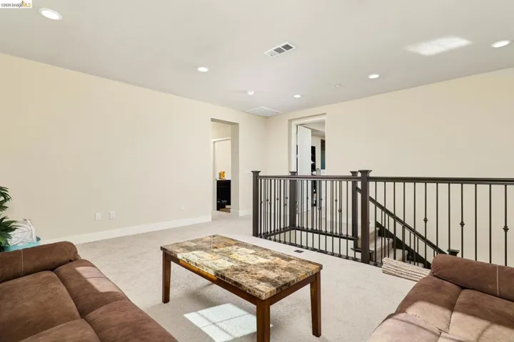 Living room with light colored carpet and recessed lighting
