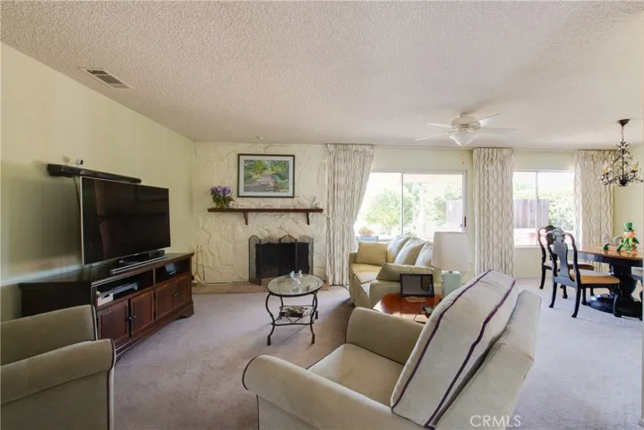 The bright living room has a floor-to-ceiling stone fireplace and recessed lights.