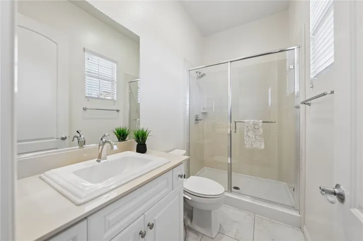 Private bath features a large vanity, walk-in shower, and a bright, functional layout.