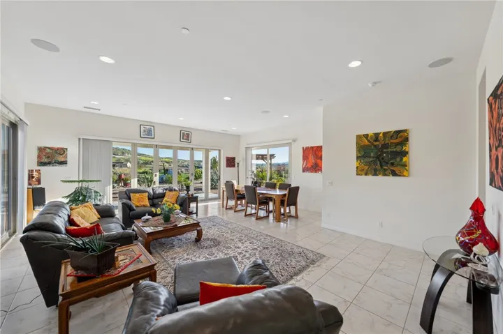 Expansive gathering space combines comfortable seating, dining area, and outdoor access for easy everyday living.