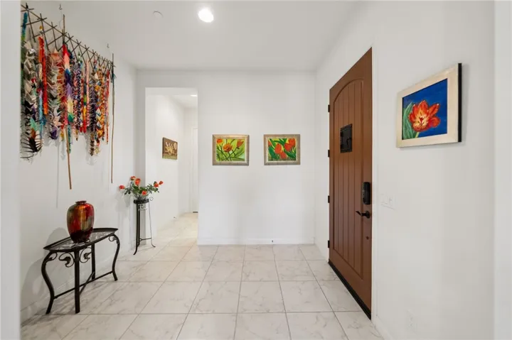 Spacious entry hall features crisp finishes, ample wall space for art, and a bright, open feel from the moment you step inside.