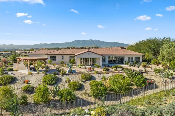 Backyard offers a covered patio, pergola seating area, and wide-open mountain views framed by low-maintenance landscaping.