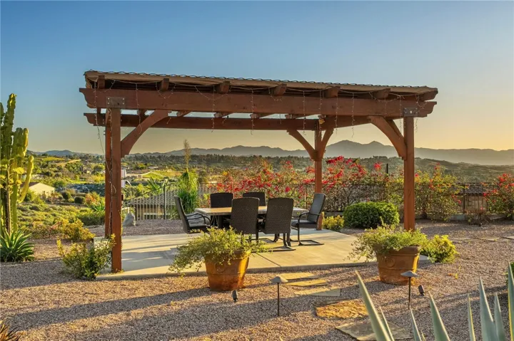 Pergola-covered patio provides a private outdoor retreat with seating space and wide-reaching hillside and neighborhood views.