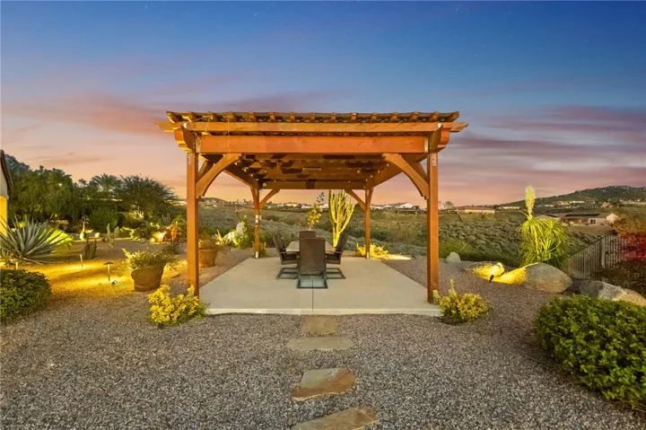 Pergola-covered dining space is positioned to enjoy the property’s elevated outlook and inviting backyard ambiance.