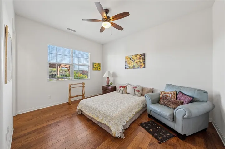 Comfortable secondary bedroom offers warm wood flooring, generous natural light, and space for guests or everyday use.