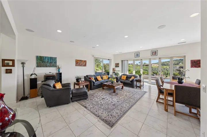 Spacious family room features tile flooring, recessed lighting, and multiple glass doors that bring in natural light and backyard views.
