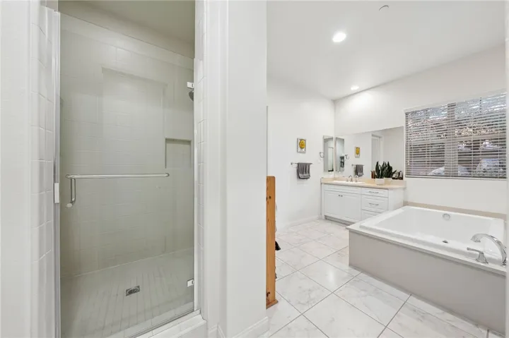 Large primary bath includes a walk-in shower, separate soaking tub, and generous vanity space for everyday comfort.