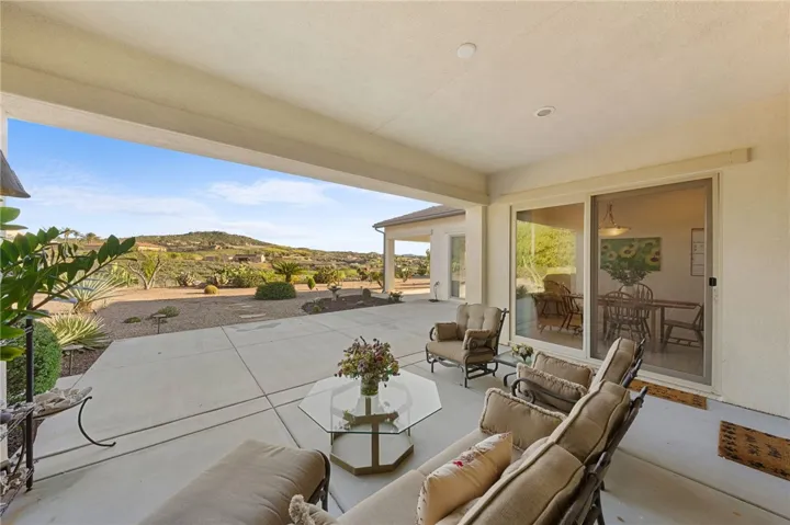 Dining space is positioned to enjoy wide backyard and hillside views through expansive sliding glass doors.
