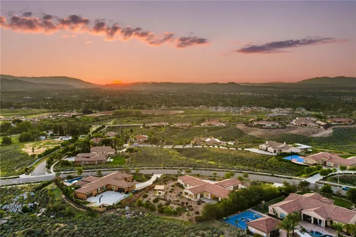 Sweeping aerial perspective highlights the property’s scenic surroundings and sunset views across the valley and rolling hills.