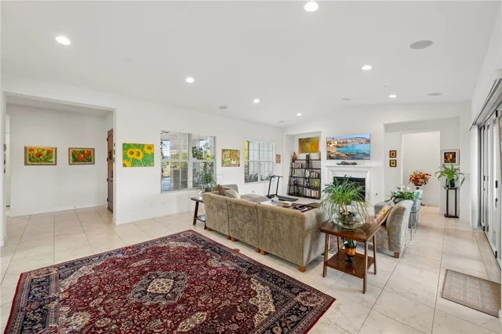 Comfortable great room features recessed lighting, large windows, and a welcoming layout centered around the fireplace.