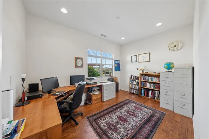 Flexible office space offers room for multiple workstations, built-in storage potential, and natural light from the large window.