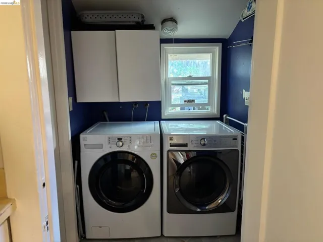 Laundry room with washing machine and clothes dryer and cabinet space