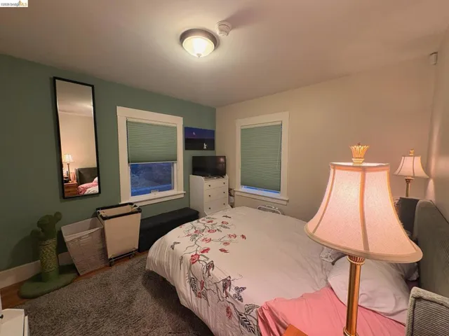 Bedroom with dark carpet and baseboards