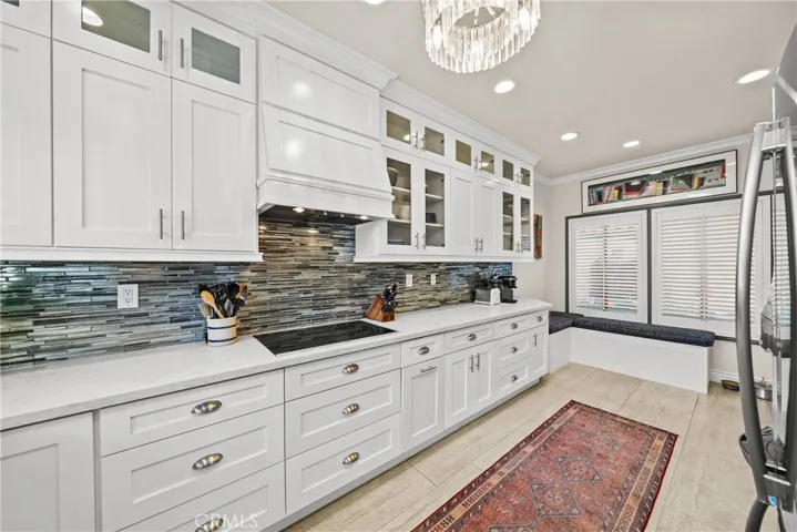 View of kitchen from sink area, notice custom banquette for sitting area in kitchen that also has storage, pantry adjacent.
