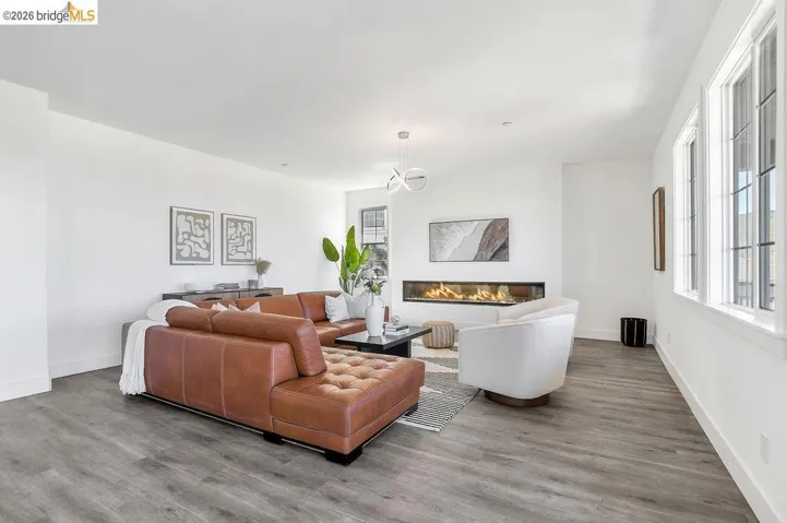 Living room featuring wood finished floors and a glass covered fireplace