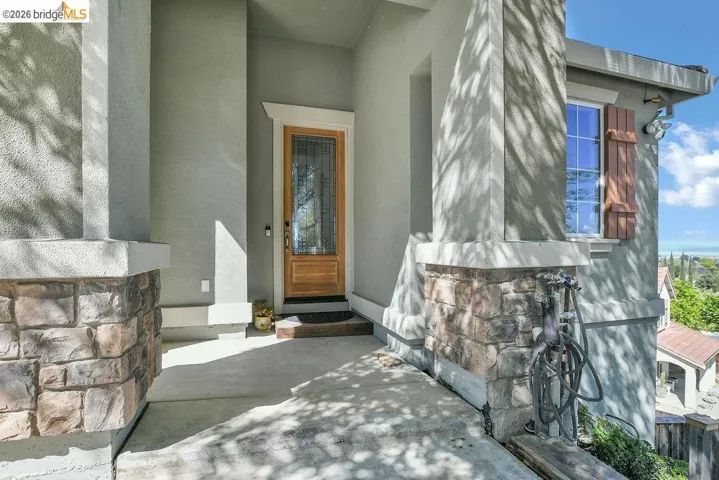 View of exterior entry with stucco siding and stone siding