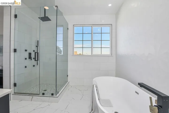 Full bathroom featuring a freestanding tub, a shower stall, and recessed lighting