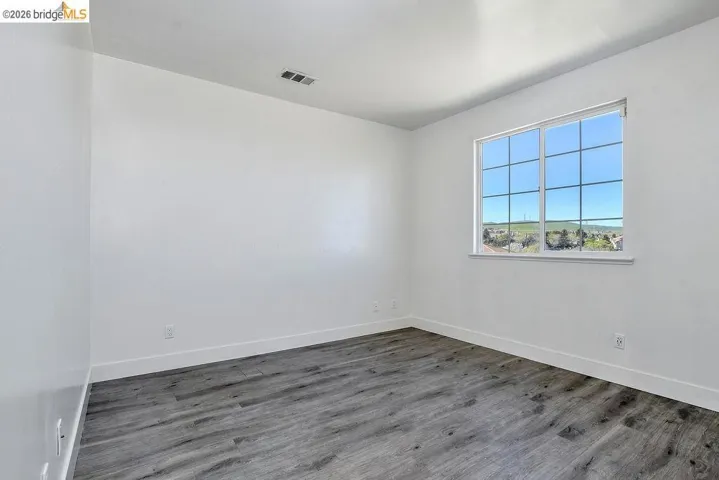 Spare room with dark wood-style flooring