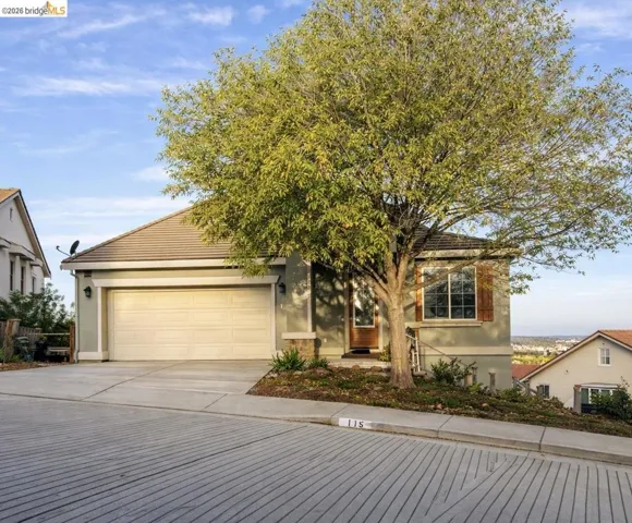 View of front of home with stucco siding, driveway, and a garage