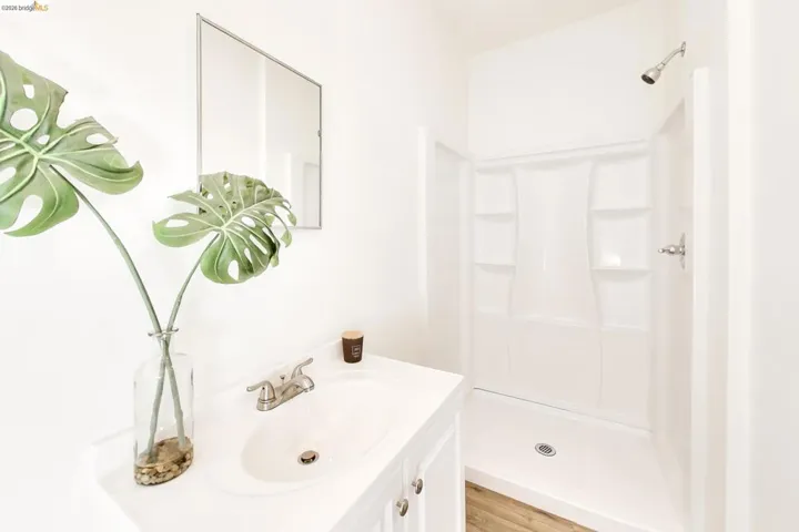 Full bath featuring vanity, a shower stall, and light wood finished floors