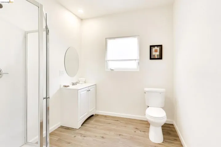 Full bath featuring light wood-style floors, vanity, a stall shower, and recessed lighting