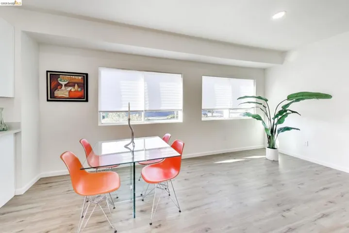 Dining room with light wood finished floors and recessed lighting