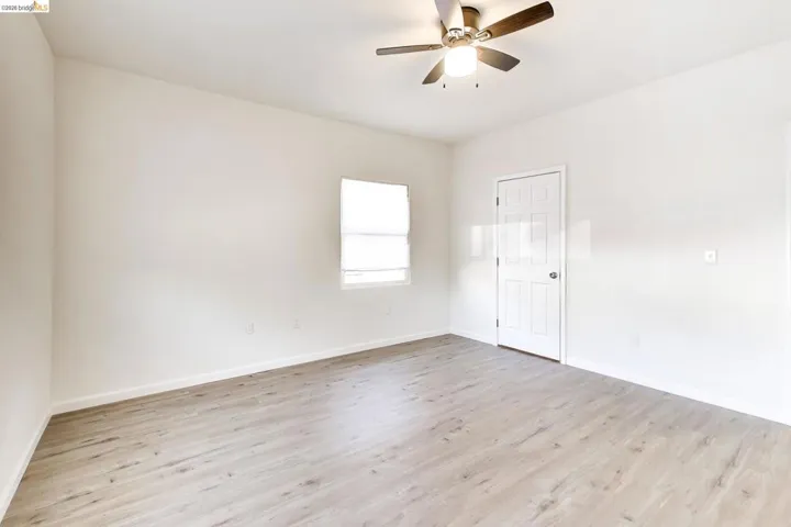 Empty room featuring ceiling fan and light wood finished floors