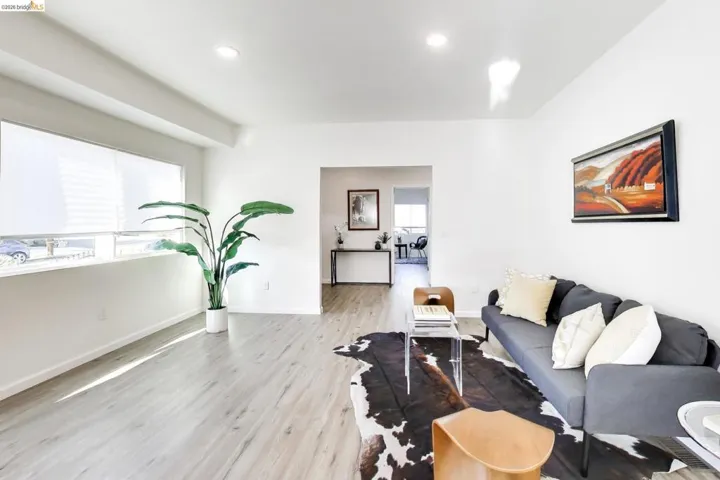 Living room with light wood-style flooring and recessed lighting