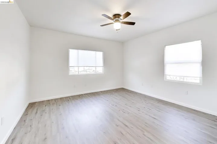 Empty room featuring light wood-style flooring and ceiling fan