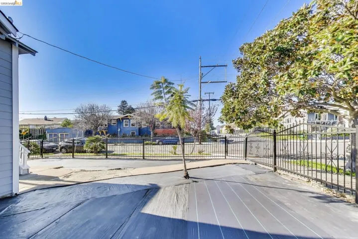 View of concrete road featuring a residential view and a gated entry