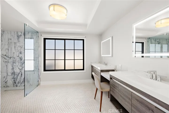 Primary bathroom, dual sinks, lit vanity mirrors