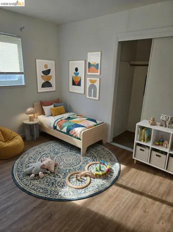 Bedroom with wood finished floors and a closet