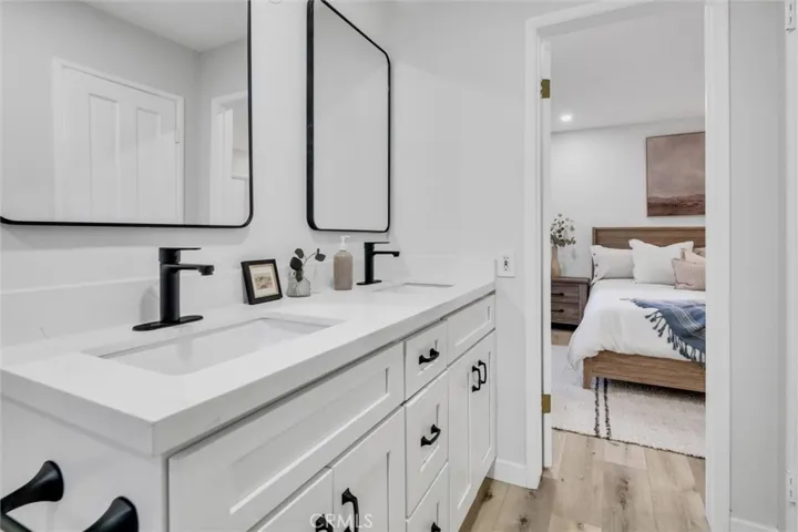 Double sinks in updated bathroom with entrance to main level bedroom