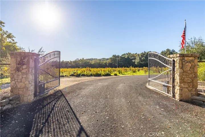 Private gated entrance with chip-seal driveway.