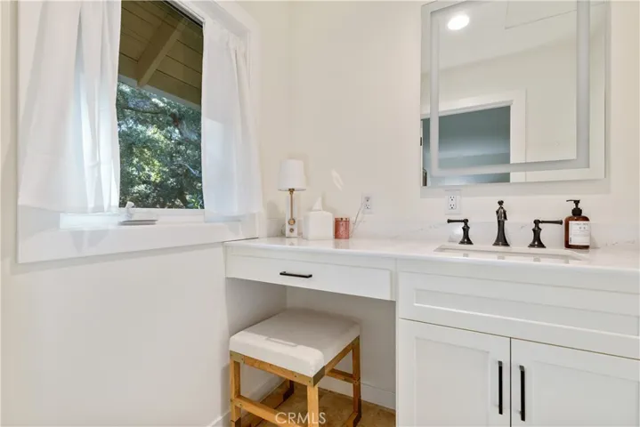 Separate vanity area featuring its own sink.